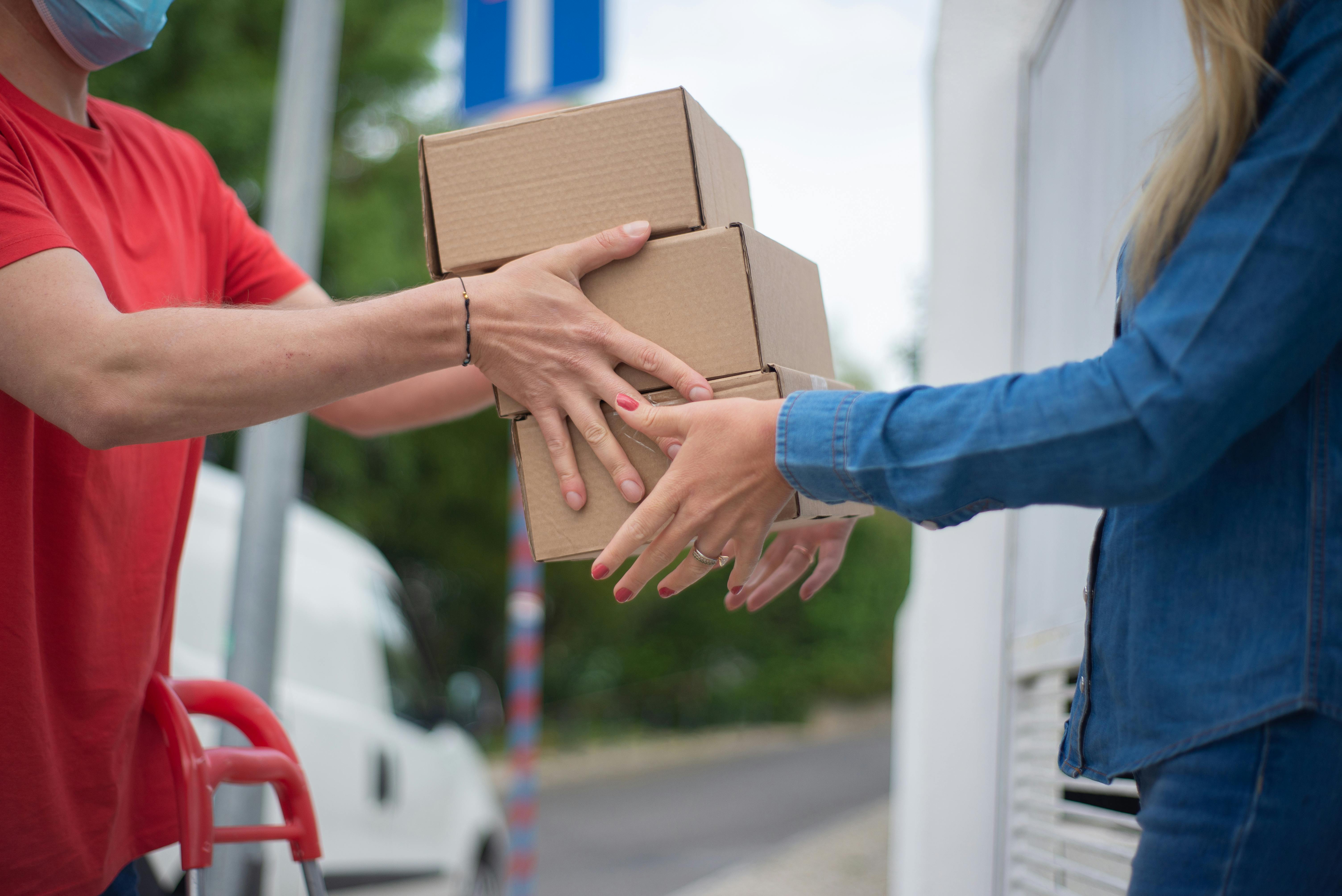 A delivery driver handing a package to a customer at the door