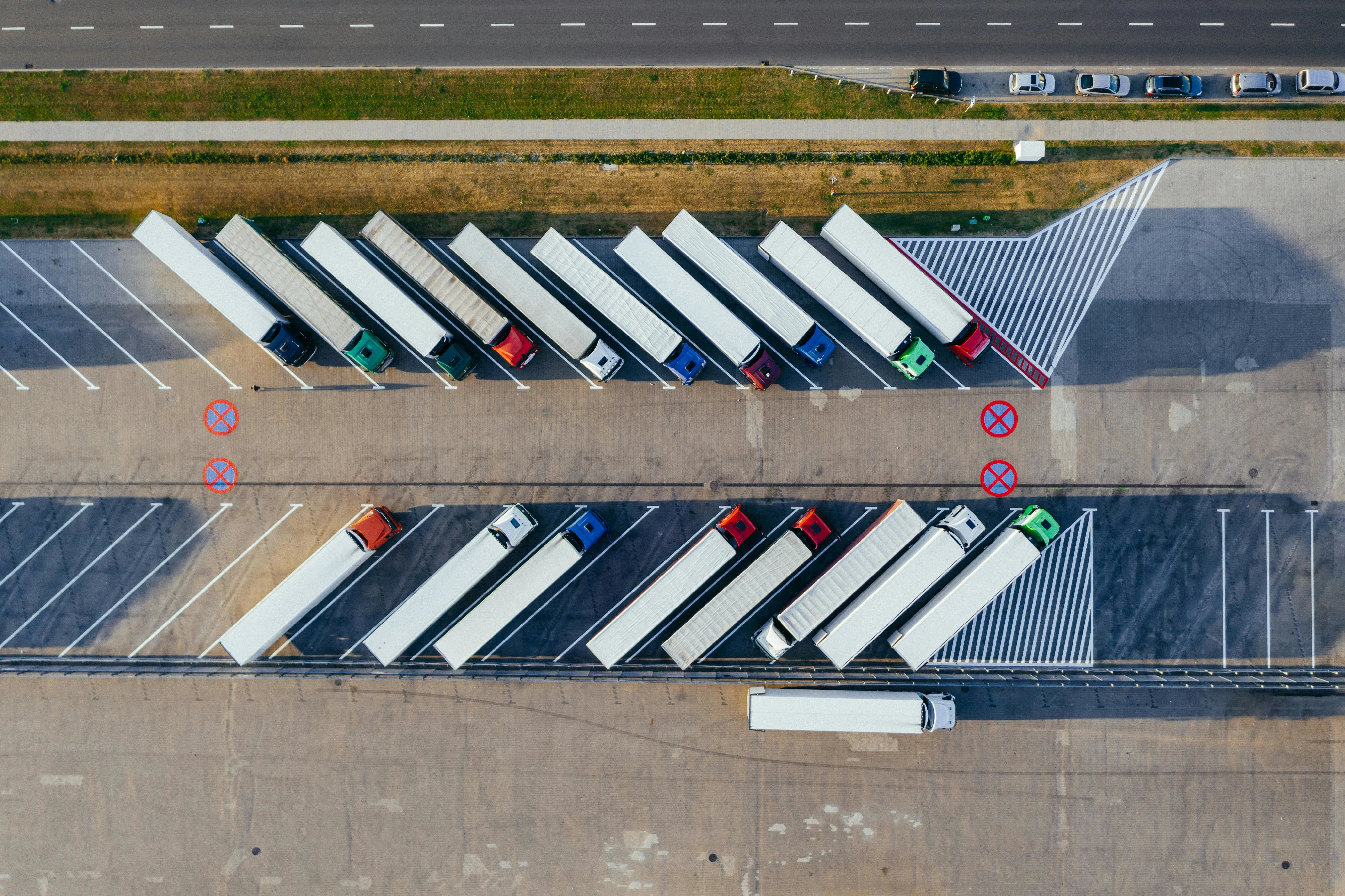 An aerial view of trucks parked in rows at a logistics depot