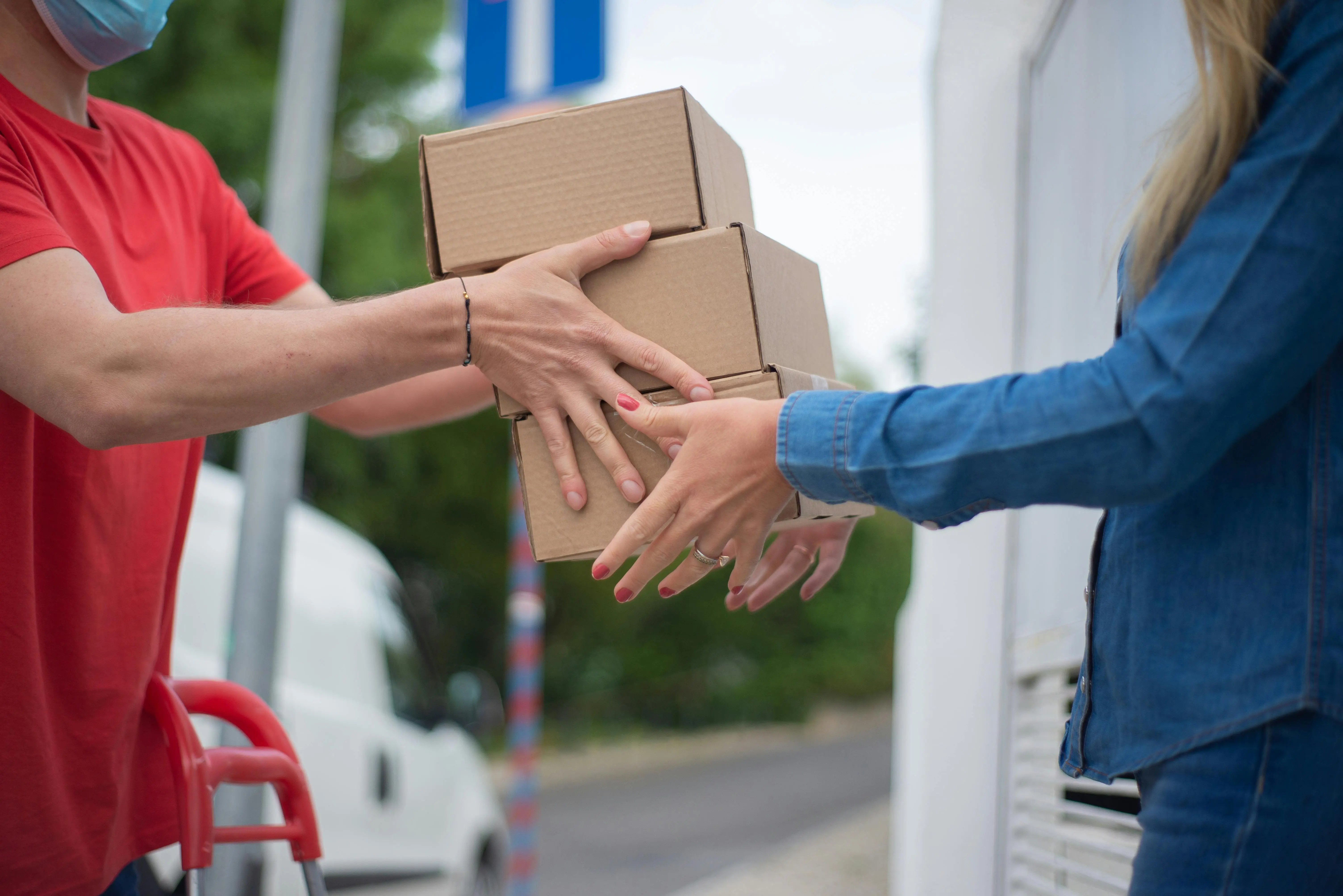 A delivery driver handing a package to a customer at the door