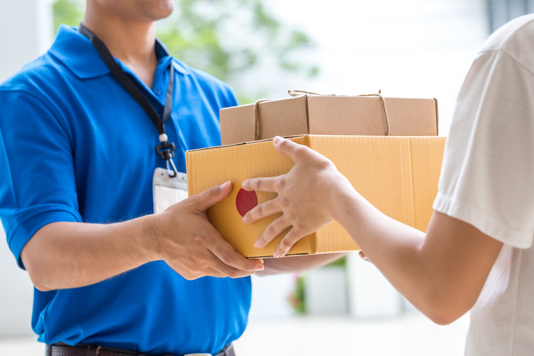 A delivery driver handing parcels to a customer at the door