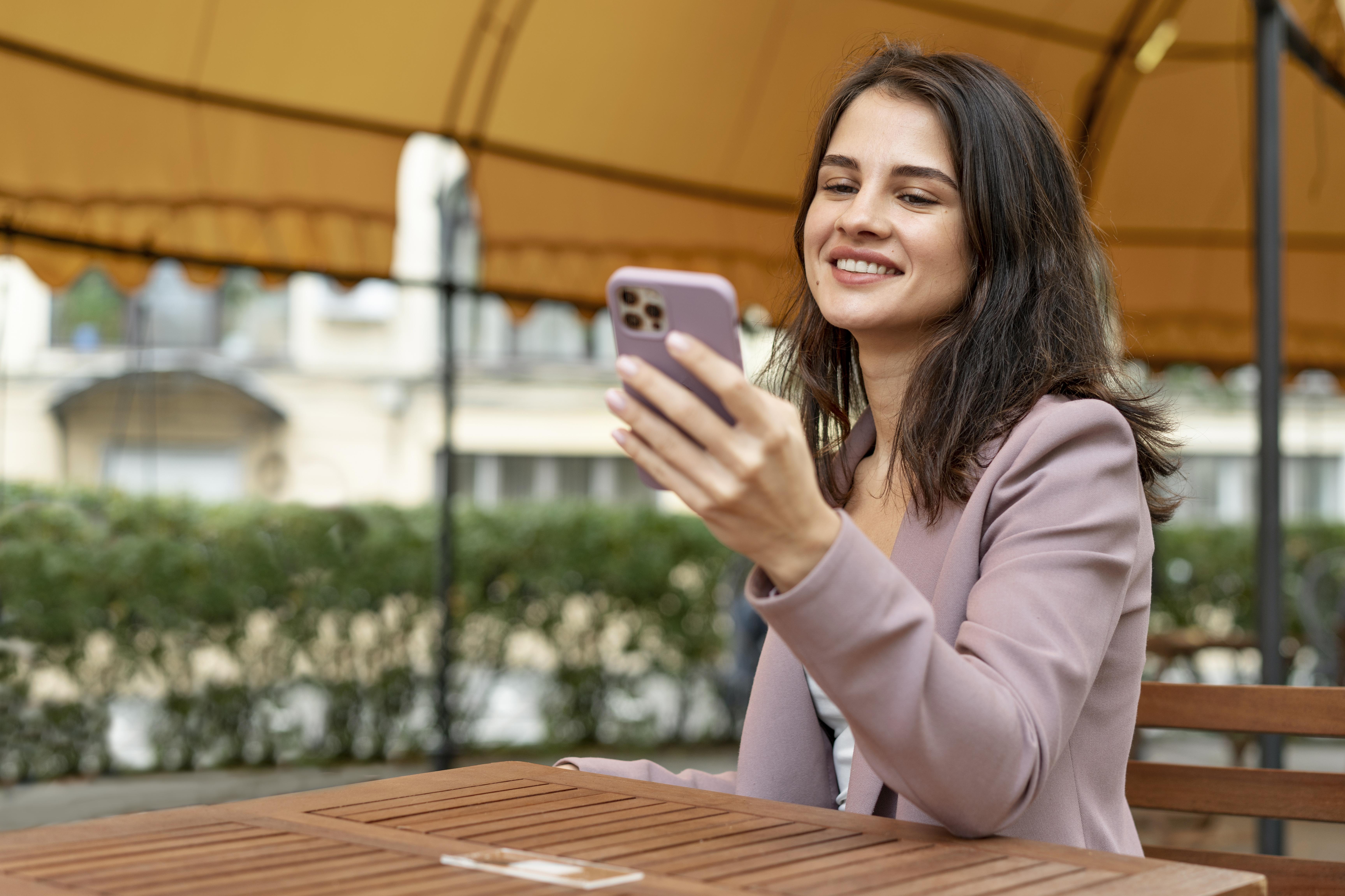A smiling customer checking a delivery update on her phone