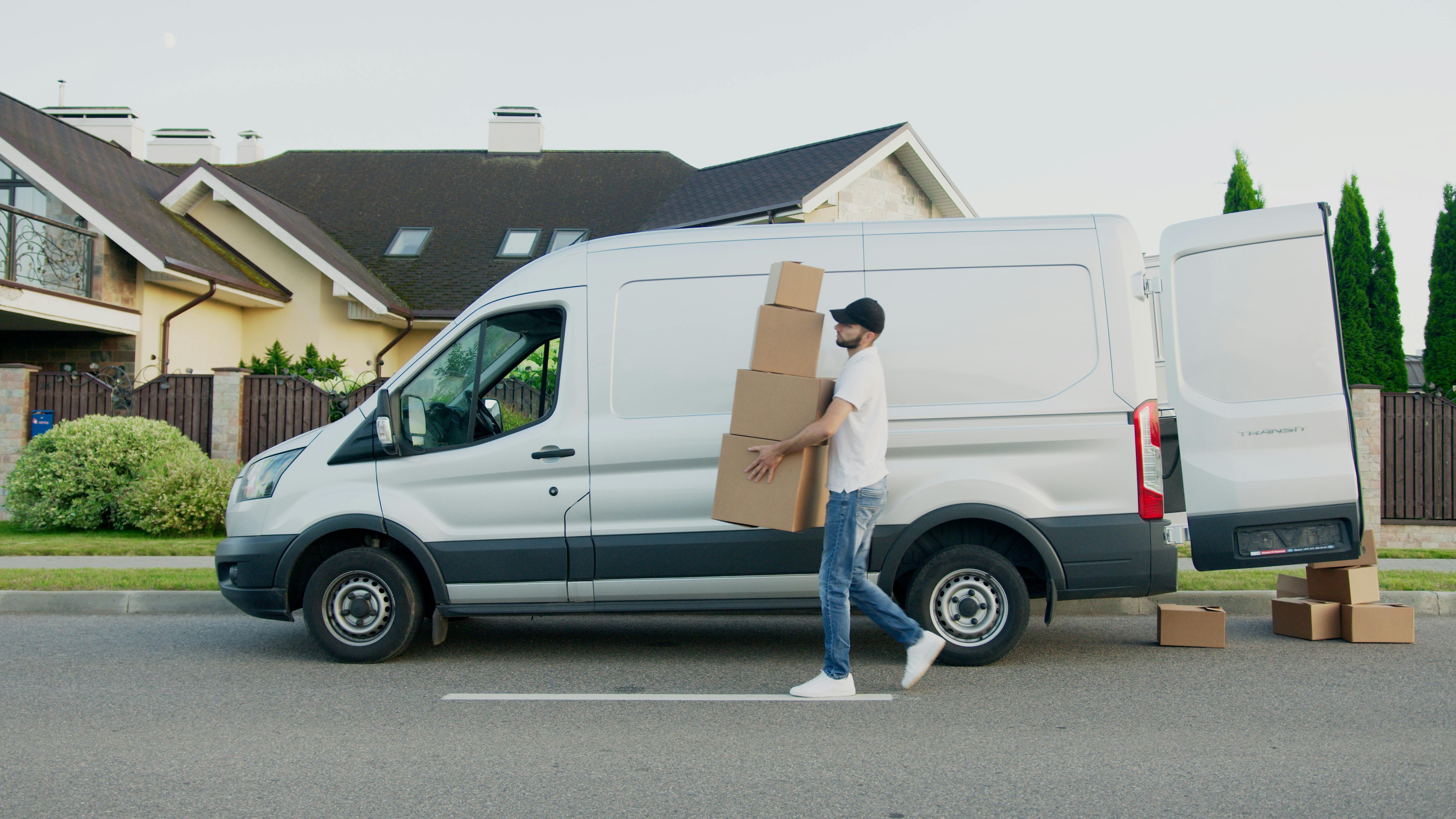 A delivery driver loading parcels into a van