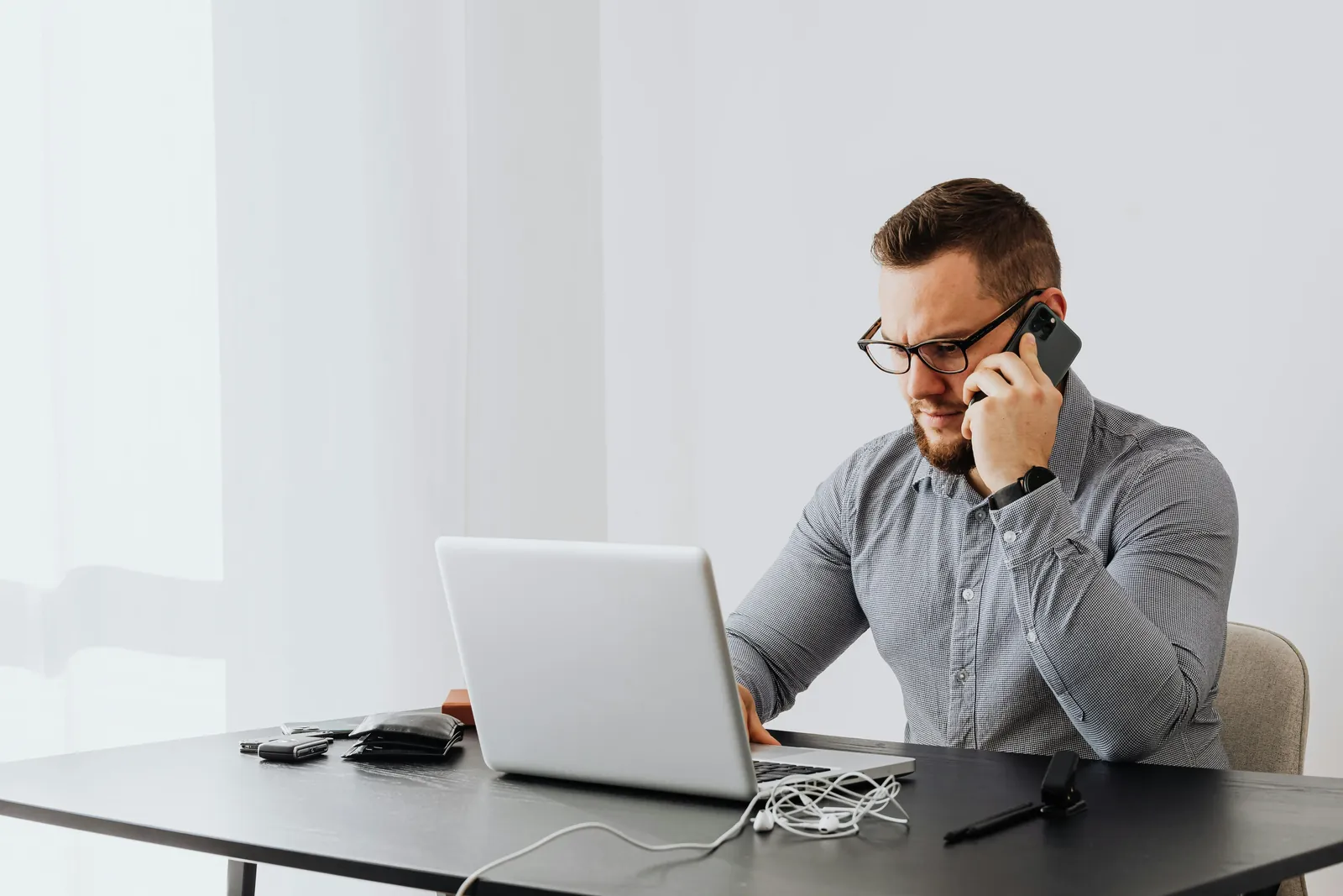 A merchant on a phone call at a laptop