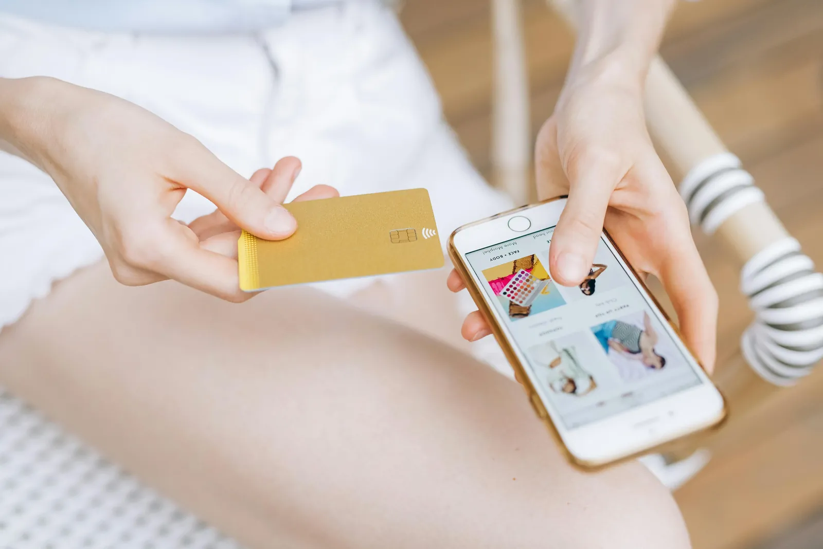 A shopper holds a payment card while browsing a store's mobile site on a phone