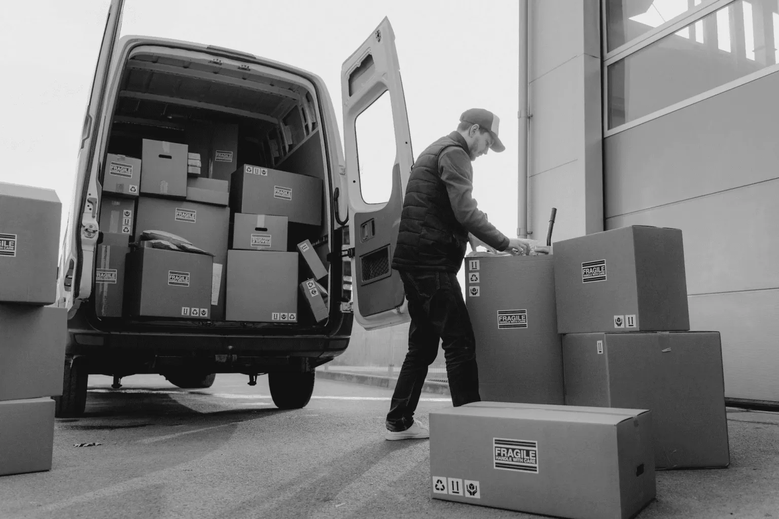 A delivery driver unloading boxes from the back of a van