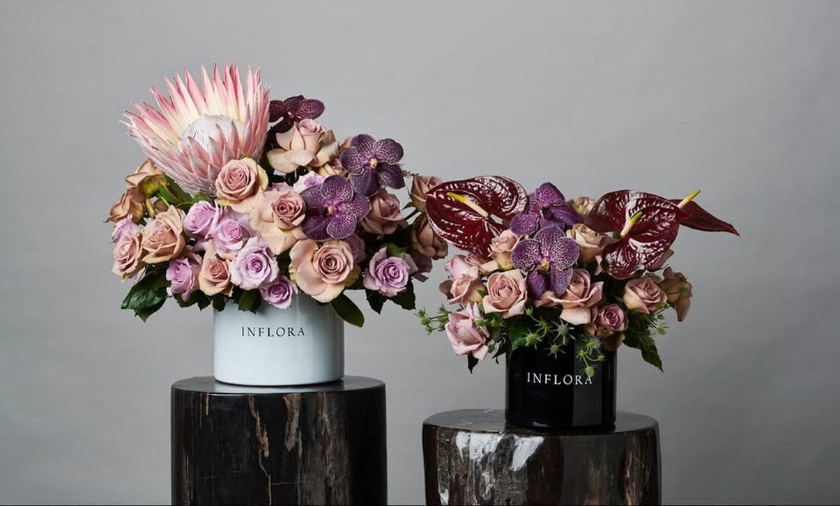 Inflora arrangements of roses, orchids and protea in white and black vases